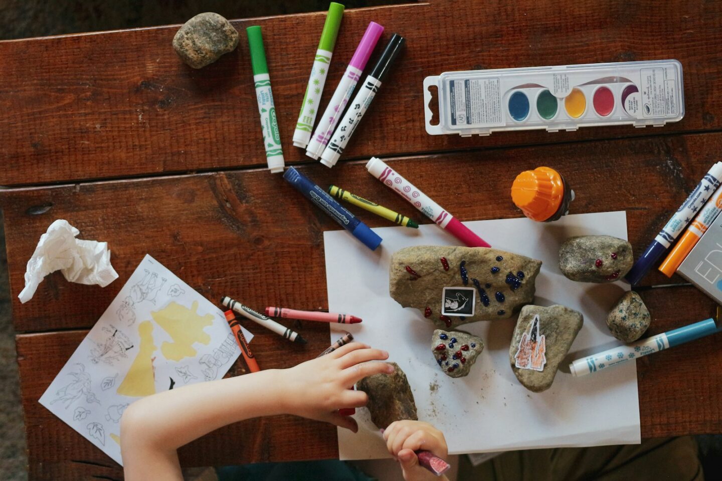 Illustrative photograph of a child making art with markers and stones. Not a Shoishob session.